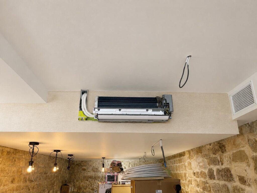 Pose de climatiseur sur mur en pierre