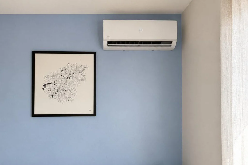 Unité intérieure murale de pompe à chaleur air/air installée en haut d'un mur bleu dans un séjour